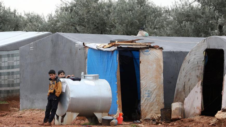 Syrian children, who fled air strikes in their hometown, are pictured near tents at an informal camp for displaced people where they live with their families in northern Syria's Idlib province on January 7, 2020. - Displaced Syrians are spending the winter out in the open and non-governmental organisations have appealed for international support ahead of a decisive UN Security Council vote on cross-border aid.
The UN Security Council was to vote on extending humanitarian aid to Syria, including to some of t