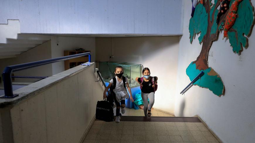 Israeli pupils wearing protective gear make their way to their classroom upon return to school after the COVID-19 lockdown, at Hashalom elementary in Mevaseret Zion, in the suburbs of Jerusalem, on May 3, 2020. - Israeli elementary schools were given the green light to bring back students of first through third grades, as the country looks to gradually transition back into a more normal routine after seven weeks of confinement measures. (Photo by Emmanuel DUNAND / AFP) (Photo by EMMANUEL DUNAND/AFP via Gett