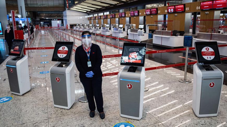 Employees wearing protective face masks wait for passengers at the Istanbul Airport  on the first day of the resumtion of domestic flights which were halted since March 26 due to the spread of the novel coronavirus, COVID-19, in Istanbul on June 1, 2020. (Photo by Yasin AKGUL / AFP) (Photo by YASIN AKGUL/AFP via Getty Images)