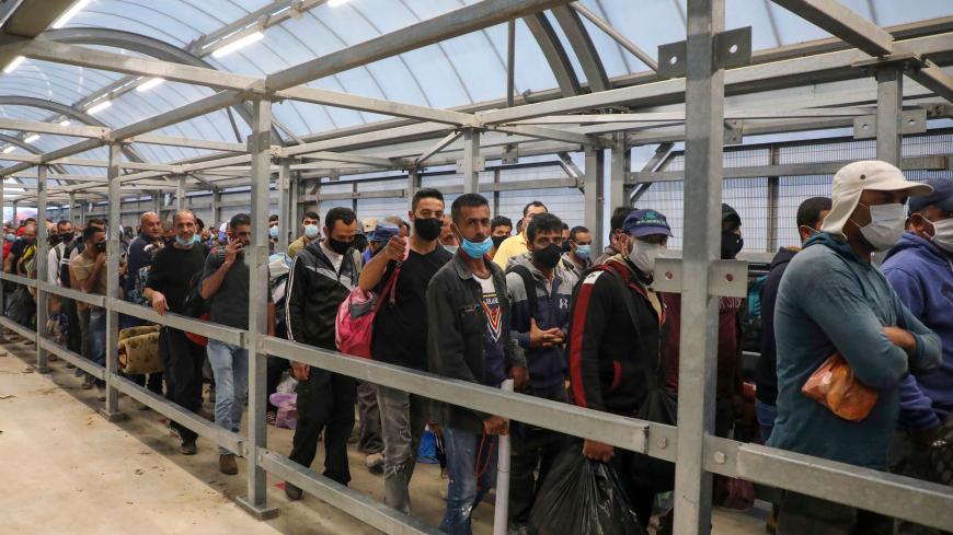 Palestinian labourers queue to enter Israel through the Mitar checkpoint in the occupied West Bank city of Hebron on June 28, 2020, (Photo by HAZEM BADER / AFP) (Photo by HAZEM BADER/AFP via Getty Images)
