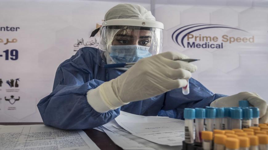 An Egyptian health worker checks samples at a drive-through coronavirus-testing center at the Ain Shams University in Cairo on June 29, 2020. - Egypt has so far registered 65,188 COVID-19 cases including 2,789 fatalities. (Photo by Khaled DESOUKI / AFP) (Photo by KHALED DESOUKI/AFP via Getty Images)