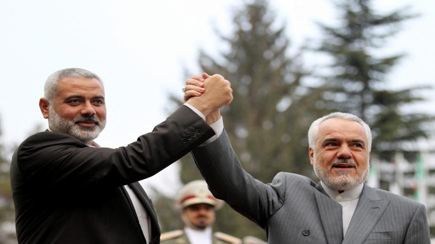 Iran's First Vice President Mohammad Reza Rahimi (R) and Ismail Haniya, Palestinian Hamas premier of Gaza, raise their hands upon the latter's arrival for a meeting in Tehran on February 10, 2012. AFP PHOTO/ATTA KENARE (Photo credit should read ATTA KENARE/AFP via Getty Images)