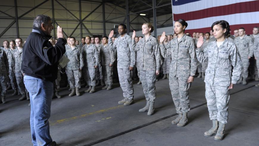 US Defense Secretary Leon Panetta (L) performs a swearing-in ceremony to re-enlist four troops during his visit to Incirlik Air Base, Turkey, on December 14, 2012. The United States will deploy two Patriot missile batteries to Turkey along with 400 troops to help defend its ally against potential threats from neighbouring Syria, US officials said on December 14. AFP PHOTO / POOL / Susan Walsh (Photo credit should read SUSAN WALSH/AFP via Getty Images)