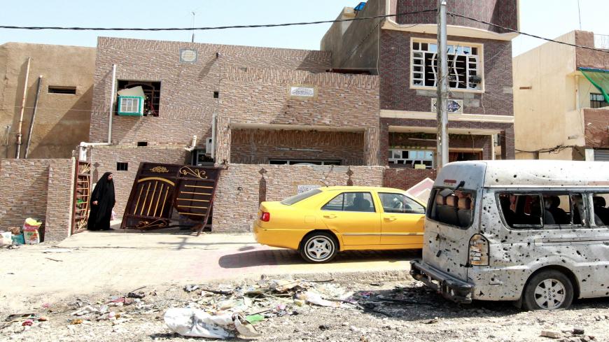 An Iraqi woman looks at the damage outside her house in a residential area of the capital, Baghdad, on July 13, 2015, the day after a car bomb explosion. A string of bomb explosions, including two suicide attacks, killed at least 21 people and wounded 62 in Shiite-dominated neighbourhoods of Baghdad, Iraqi police and medical sources said. AFP PHOTO / SABAH ARAR (Photo credit should read SABAH ARAR/AFP via Getty Images)