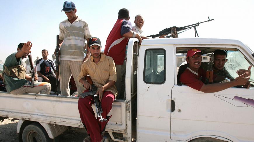 Former Iraqi insurgents, members of the Sunni Anbar Awakening, guard a meeting between Sunni and Shiite tribe leaders and clerics in al-Duwanem, southwest of Baghdad, 25 September 2007. The aim of the meeting is to bring back life to the town after it was cleared from al-Qaeda. The formation of the Sahwat al-Anbar, or Anbar Awakening, the grouping of Anbari tribes and former insurgents opposed to Al-Qaeda, traces back to last year, when Al-Qaeda in Iraq conducted its campaign of murder and intimidation thro