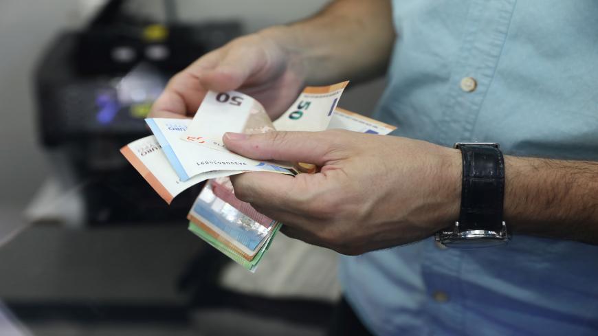 An employee counts money at a currency exchange office in Ankara, on August 7, 2020. - Turkey's lira on August 7, 2020 set a new record low against the US dollar as investors worried about the government's economic policies and dollar reserves appeared to be running low. (Photo by Adem ALTAN / AFP) (Photo by ADEM ALTAN/AFP via Getty Images)