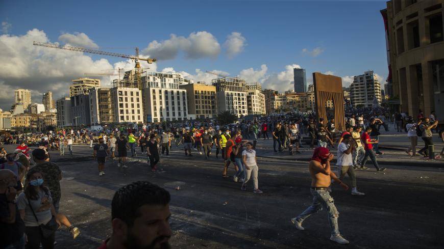 BEIRUT, LEBANON - AUGUST 09: People make their way toward a a clash happening between two separate factions of protestors during a protest at Martyrs Square on August 9, 2020 in Beirut, Lebanon. Large protests continued for a second day as the Lebanese capital reels from this week's massive explosion that killed more than 150 people, wounded thousands, and destroyed wide swaths of the city. Residents are demanding accountability for the blast, whose suspected cause was 2,700 tons of ammonium nitrate stored 