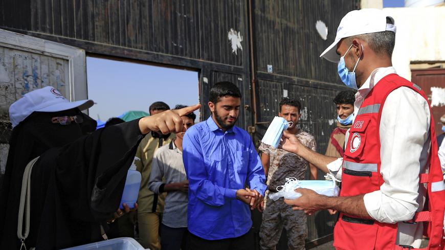 Face masks are distributed to Yemeni students upon their arrival to sit for their final secondary school exams in the capital Sanaa on August 15, 2020, amid the coronavirus pandemic crisis. (Photo by Mohammed HUWAIS / AFP) (Photo by MOHAMMED HUWAIS/AFP via Getty Images)