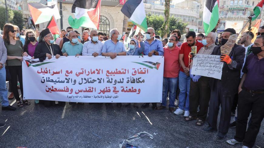 Palestinian protesters lift a banner during a demonstration against the Emirati-Israeli agreement in Ramallah in the occupied West Bank, on August 15, 2020. (Photo by ABBAS MOMANI / AFP) (Photo by ABBAS MOMANI/AFP via Getty Images)