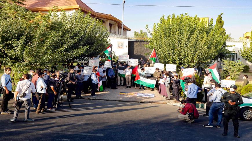 Iranian students wave Palestinian flags and hold banners during a protest against a US-brokered deal between Israel and the UAE to normalise relations, in front of the UAE embassy in the capital Tehran, on August 15 2020. (Photo by - / AFP) (Photo by -/AFP via Getty Images)