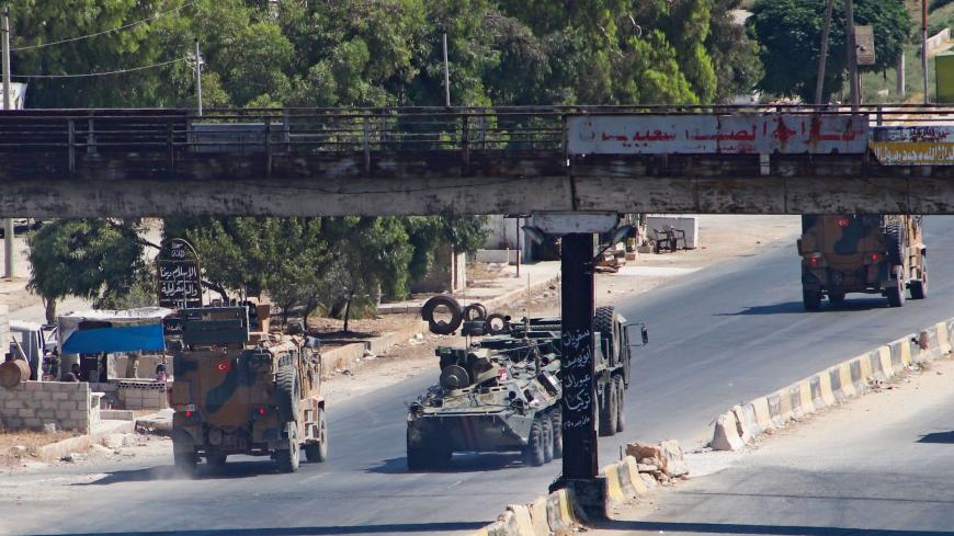 A Turkish-Russian military convoy tows a damaged vehicle after its joint patrol was reportedly targeted on the strategic M4 highway, near the Syrian town of Urum al-Jawz in the south of the northwestern Idlib province, on August 25, 2020. - Russia and Turkey launched joint patrols along the M4 highway in March following a ceasefire agreement aimed at stopping heavy fighting in and around Idlib, the last major bastion of anti-government forces in Syria's civil war. (Photo by Abdulaziz KETAZ / AFP) (Photo by 
