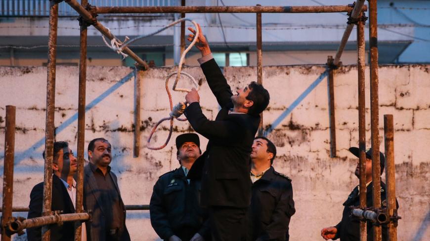 Iranian officials prepare the noose for the execution of Balal, who killed fellow Iranian youth Abdolah Hosseinzadeh in a street fight with a knife in 2007, during his execution ceremony in the northern city of Noor on April 15, 2014. Samereh Alinejad, the mother of  Abdolah Hosseinzadeh, spared the life of Balal, her son's convicted murderer, with an emotional slap in the face as he awaited execution prior to removing the noose around his neck with the help of her husband. AFP PHOTO/ARASH KHAMOOSHI/ISNA   