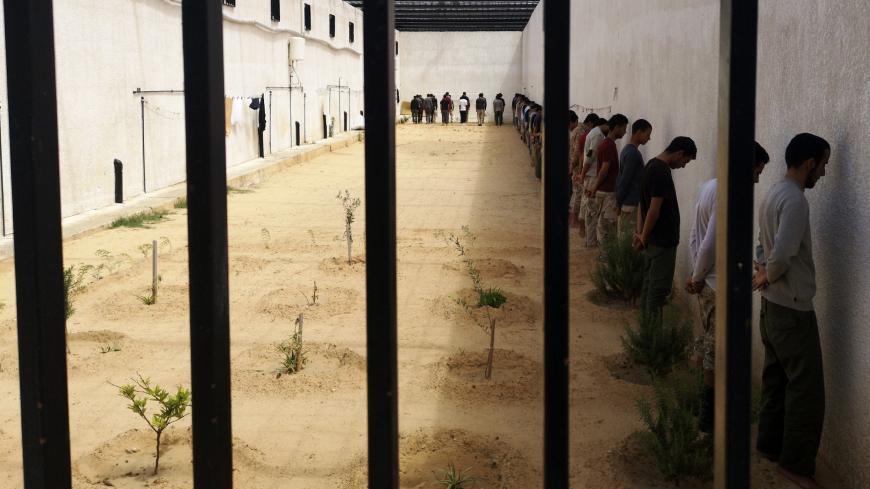 TOPSHOT - A picture taken on April 11, 2019, shows fighters loyal to military commander Khalifa Haftar imprisoned by forces from the UN-backed Government of National Accord (GNA) in Tripoli's suburb of Ain Zara on April 11, 2019. - Heavy clashes were heard Wednesday in the Ain Zara district on the southeastern outskirts of Tripoli as military strongman Khalifa Haftar's forces pressed an assault aimed at taking the capital from the UN-backed Government of National Accord (GNA). (Photo by Imed LAMLOUM / AFP) 