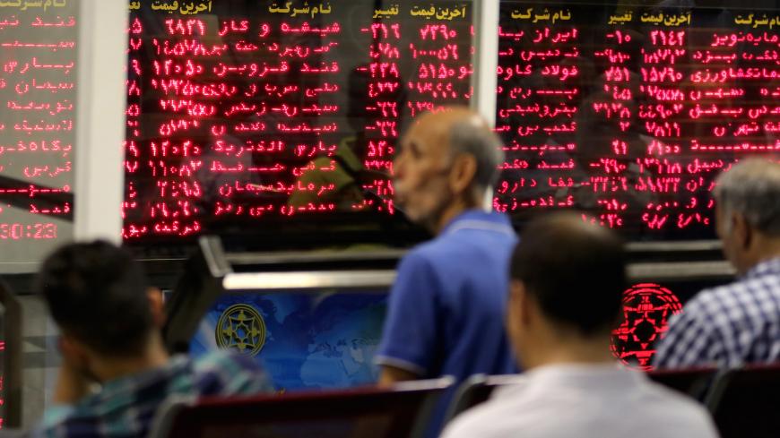 Iranian men monitor the stock market at Tehran Stock Exchange on July 1, 2019. - Iran's stock market is thriving, despite US sanctions which have battered its economy and an uncertain future as geopolitical tensions soar in the Gulf. Its main index, TEDPIX, has steadily risen over the last 12 months, accelerating in the most recent quarter to hit a historic high of 248,577 last week -- more than twice its level a year ago. (Photo by ATTA KENARE / AFP)        (Photo credit should read ATTA KENARE/AFP via Get