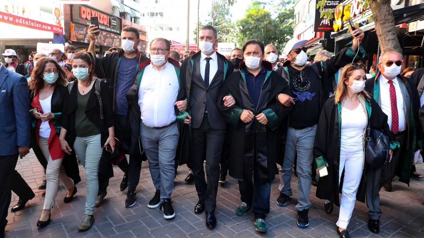 Protesting lawyers lock arms as they march during a demonstration against a government draft bill on changing the system of bar associations on July 10, 2020, in Ankara. - Turkey's ruling party on June 30 presented a bill to parliament on changing the system of bar associations that opponents say will dent lawyers' independence and influence. (Photo by Adem ALTAN / AFP) (Photo by ADEM ALTAN/AFP via Getty Images)