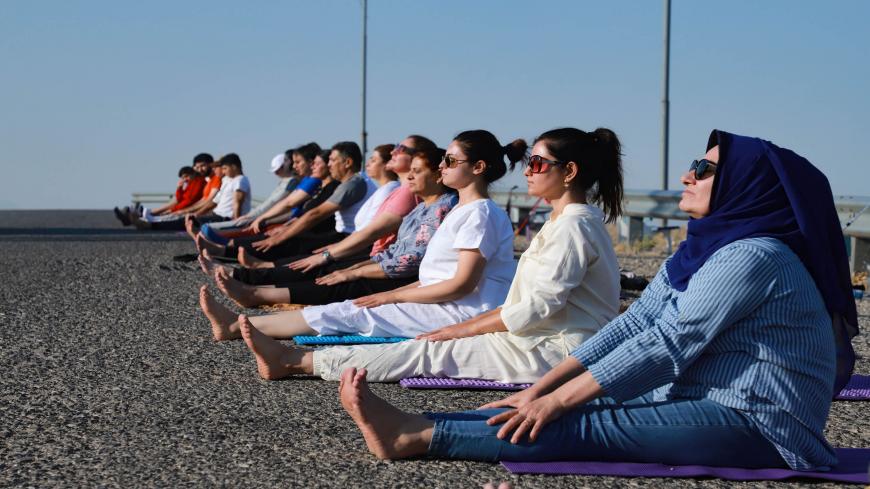 Kurdish Iraqi men and women practice yoga on Mount Azmar, which overlooks the northern city of Sulaimaniyah in Iraq's autonomous Kurdish region, on July 19, 2020. - According to kurdish Iraqi Yoga instructor Muhammad Sherzade, an increasing number of people joined his class since he established his school in the region in 2016, following the outbreak earlier this year of the coronavirus epidemic. (Photo by Shwan MOHAMMED / AFP) (Photo by SHWAN MOHAMMED/AFP via Getty Images)