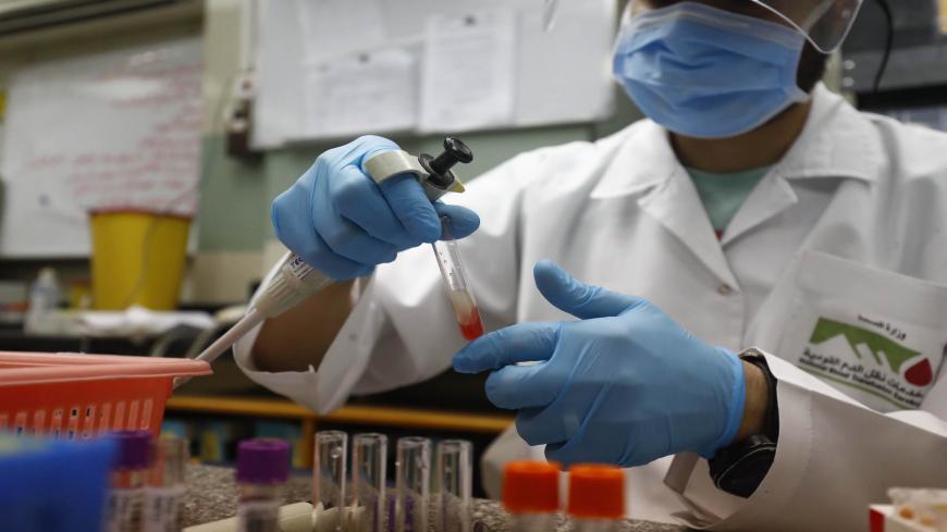 An Egyptian medical worker checks the blood of a man who recovered from Covid-19 at the National Blood Transfusion centre in Cairo on July 22, 2020. (Photo by Khaled DESOUKI / AFP) (Photo by KHALED DESOUKI/AFP via Getty Images)