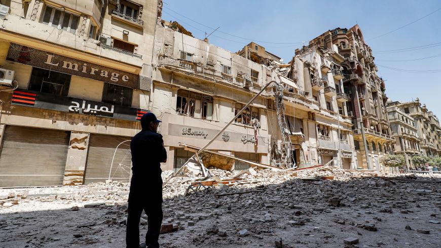 A policeman stands by the rubble at the scene of a building collapse along Kasr el-Nile street in the Egyptian capital Cairo's downtown district, on August 15, 2020. (Photo by Khaled DESOUKI / AFP) (Photo by KHALED DESOUKI/AFP via Getty Images)