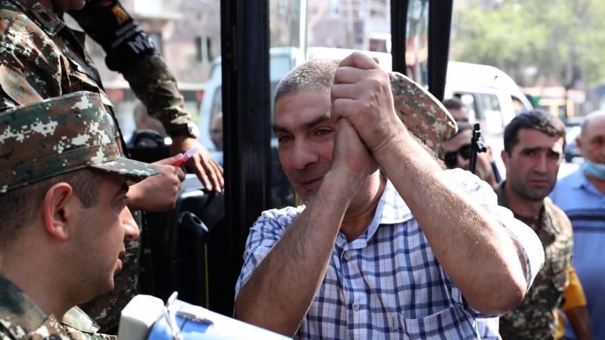 A man gestures boarding a bus to depart to the breakaway Nagorno-Karabakh region after Armenian authorities declared military mobilisation following armed clashes with Azerbaijan, Yerevan, September 28, 2020. (Photo by Stepan Poghosyan / PHOTOLURE / AFP) (Photo by STEPAN POGHOSYAN/PHOTOLURE/AFP via Getty Images)
