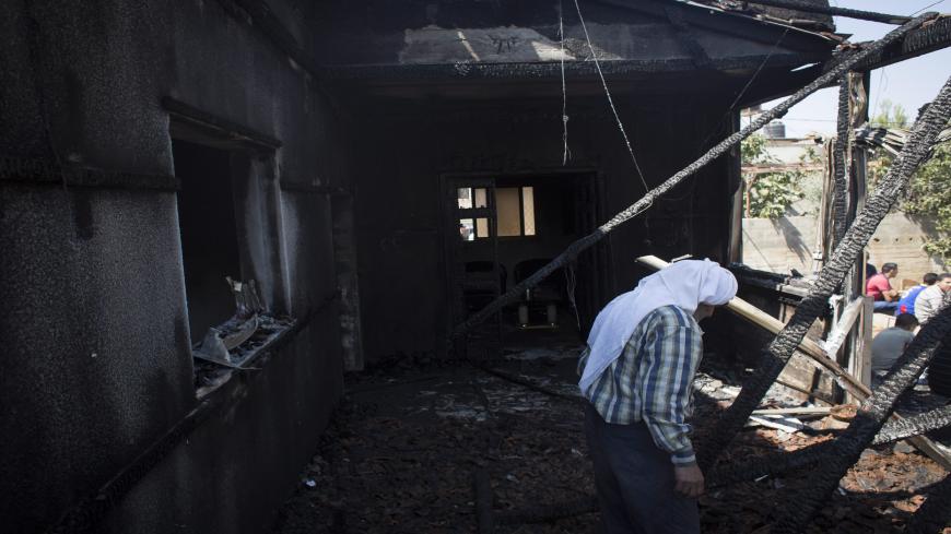 DUMA,WEST BANK - JULY 31: Family members and relatives of 18 month old baby, Ali Saad-Dawabsheh, view the remains of their house after a fire which was suspected to have been set by Jewish extremists on July 31, 2015 in the Palestinian village of Duma, West Bank. A house fire in the Palestinian village of Duma, West Bank, suspected to have been set by Jewish extremists, killed an 18-month-old Palestinian child, injured both parents and a four year old brother. (Photo by Oren Ziv/Getty Images)