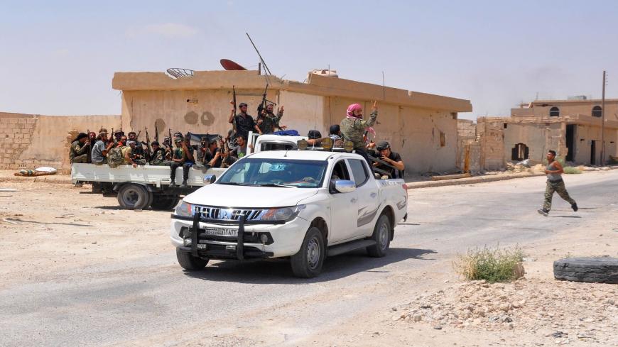 Pro-government fighters sit in the back of vehicles brandishing their weapons and flashing the sign for victory in the central Syrian town of Al-Sukhnah, situated in the county's large desert area called the Badiya, on August 13, 2017 as they clear the area after taking control of the city from Islamic State (IS) group fighters. 
Supported by regime ally Russia, Syria's army has waged a months-long offensive to recapture the vast desert region that stretches from the country's centre to the Iraqi and Jordan