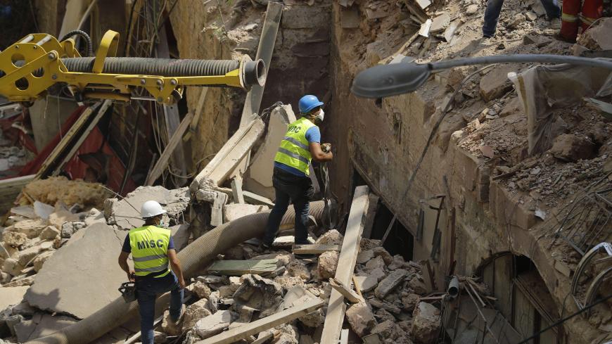 Rescue workers prepare to use a tube to vacuum debris from a badly damaged building in Lebanon's capital Beirut, in search of possible survivors from a mega-blast at the adjacent port one month ago, after scanners detected a pulse, on September 4, 2020. - Lebanese rescuers scoured rubble for a possible survivor in Beirut after the detection of a pulse drew crowds hopeful of a miracle one month on from a devastating explosion. (Photo by JOSEPH EID / AFP) (Photo by JOSEPH EID/AFP via Getty Images)