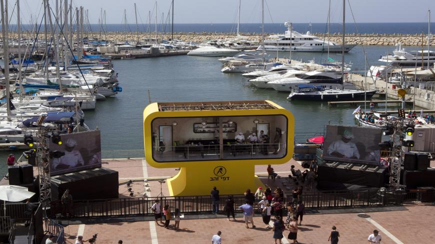 Israeli TV personalities Eliraz Sade (R) and Nathan Bashevkin (L) take part in the �Live billboard' event at the marina in Herzliya, north of Tel Aviv, on September 28, 2010. AFP PHOTO / JACK GUEZ (Photo credit should read JACK GUEZ/AFP via Getty Images)