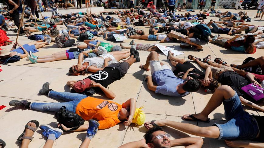Israeli activists and demonstrators hold placards as they take part in a Global Climate Strike in the Israeli coastal city of Tel Aviv on September 27, 2019 against inaction on climate change. (Photo by AHMAD GHARABLI / AFP)        (Photo credit should read AHMAD GHARABLI/AFP via Getty Images)