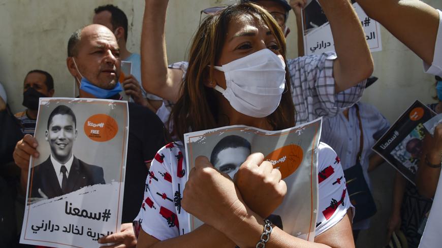 Algerian journalists gather in protest to demand the release of their colleague Khaled Drareni (poster), who was sentenced earlier this month to three years in jail for "inciting an unarmed gathering" and "endangering national unity", in the capital Algiers on August 24, 2020. - The Algerian justice system has in recent months increased the court cases and convictions against alleged Hirak militants, opposition politicians, journalists and social media users. (Photo by RYAD KRAMDI / AFP) (Photo by RYAD KRAM
