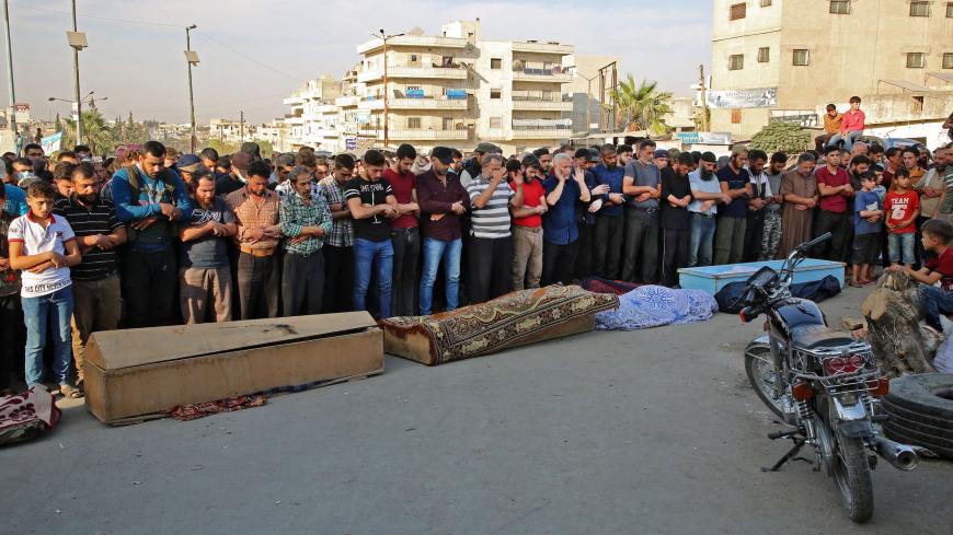 Syrians take part in the funeral of 10 fighters with the Turkey-backed Faylaq al-Sham rebel faction in Syria, in the northwestern city of Idlib, on October 26, 2020, following their death in a Russian air strike. - Air strikes by Syrian regime ally Russia killed 78 fighters from the turkey-backed Faylaq al-Sham faction when they targeted a training camp in the Jabal Duwayli area in Idlib province, the Syrian Observatory for Human Rights said. (Photo by Mohammed AL-RIFAI / AFP) (Photo by MOHAMMED AL-RIFAI/AF