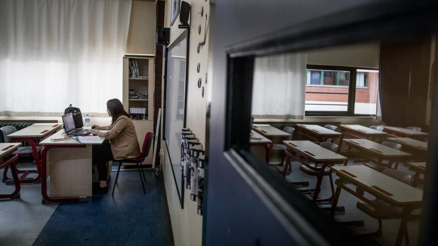 ISTANBUL, TURKEY - SEPTEMBER 21: Second grade teacher Meltem Capkin sits in an empty classroom while conducting an online class at the Florya Ugur College on September 21, 2020 in Istanbul, Turkey. For the first time since schools closed on March 16, due to the coronavirus outbreak, kindergarten and first grade students were allowed to return for in-person classes at schools across Turkey. The one day a week classes are voluntary and restarted amid strict coronavirus precautions. As coronavirus cases contin