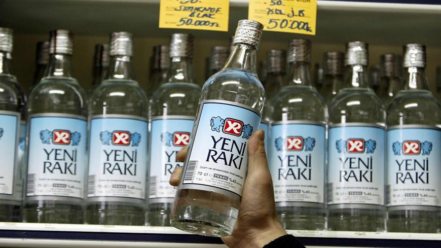 ISTANBUL, TURKEY:  A shop keeper shows a legally produced Turkish Raki in Istanbul 03 March 2005. The deaths of nine people from bootleg liquor has sparked panic in Istanbul drinking establishments, with many bar owners blaming higher taxes on alcoholic beverages by a government with Islamist roots for the emergence of illegal liquor factories. AFP PHOTO/Mustafa Ozer  (Photo credit should read MUSTAFA OZER/AFP via Getty Images)