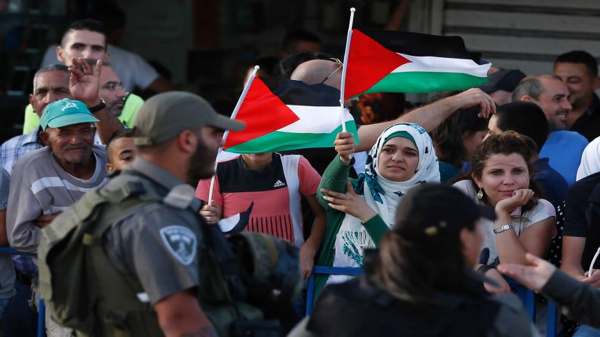 Palestinian demonstrators are separated by Israeli police barriers from Israelis celebrating Jerusalem Day, that marks the anniversary of the "reunification" of the holy city after Israel captured the Arab eastern sector from Jordan during the 1967 Six-Day War, outside Damascus Gate in Jerusalem's old city on June 5, 2016.
Israel occupied east Jerusalem in 1967 and later annexed it in a move never recognized by the international community. / AFP / AHMAD GHARABLI (Photo credit should read AHMAD GHA