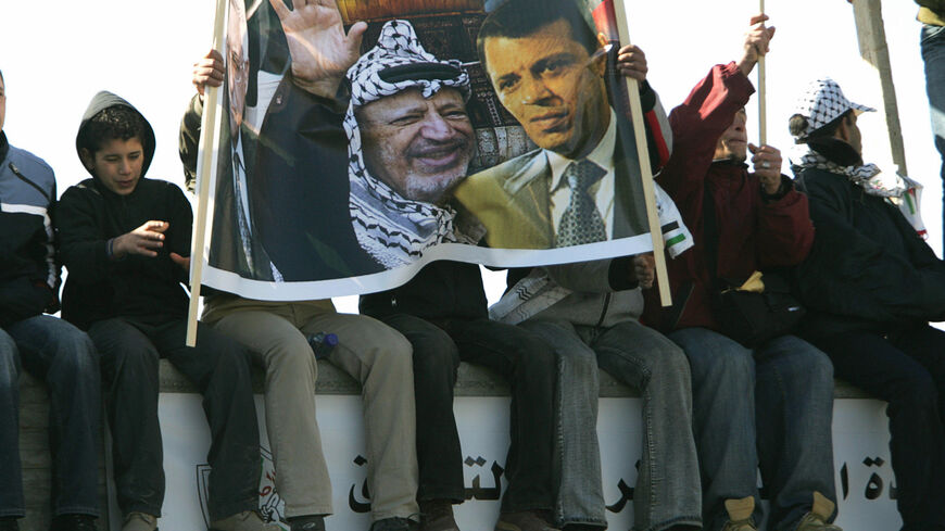 RAMALLAH, -:  Palestinians hold a banner showing late Palestinian leader Yasser Arafat (L) and Fatah MP Mohammed Dahlan during a rally in the West Bank city of Ramallah 11 January 2007, to mark the 42nd anniversary of the Fatah movement. Thousands of flag-waving chanting supporters of Palestinian president Mahmud Abbas's Fatah party poured into central Ramallah for a second rally in less than a week aimed at staging a show of force agains the ruling Hamas movement. AFP PHOTO/PEDRO UGARTE  (Photo credit shou