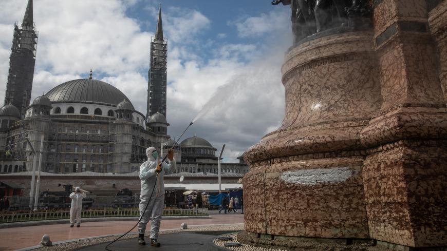 ISTANBUL, TURKEY - MARCH 18: An employee from Istanbul Municipality disinfects the Taksim Republic Statue in Taksim square to prevent the spread of the COVID-19, coronavirus on March 18, 2020 in Istanbul, Turkey. Turkey has  confirmed one death and ninety eight positive cases of the coronavirus and officials continue to implement steps to contain the spread of the virus with the Interior Ministry announcing cafes, cinemas, restaurants, shish-a cafes, bars and gyms will close adding to schools, universities 
