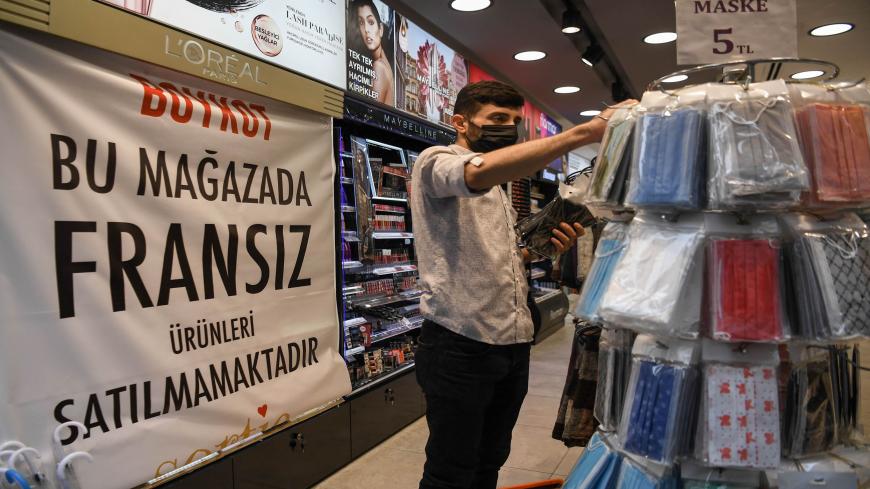 An employee works in a shop near a banner reading "Boycott, We do not sell French products in this shop" on October 30,2020 in Istanbul. - Turkish President joined calls on October 26, 2020 for a boycott of French goods, ramping up a standoff between France and Muslim countries over Islam and freedom of speech. (Photo by Ozan KOSE / AFP) (Photo by OZAN KOSE/AFP via Getty Images)