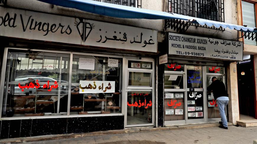 A picture shows a man standing at the booth of a money exchange company in the city of Jounieh north of Beirut on December 01, 2020. - Lebanon's economy is sinking into a "deliberate depression", the World Bank said on December 1 in a damning report stressing the authorities' failure to tackle the crisis. Lebanon's economy started collapsing last year as a result of years of corrupt practices and mismanagement. The crisis was made worse by a nationwide wave of anti-government protests that paralysed the cou