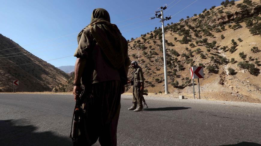 A member of the Kurdistan Workers' Party (PKK) carries an automatic rifle on a road in the Qandil Mountains, the PKK headquarters in northern Iraq, on June 22, 2018. - Hundreds of Iraqi Kurds marched Friday to protest Turkish strikes against the Kurdistan Workers' Party (PKK) after Turkey's President Recep Tayyip Erdogan said Ankara would press an operation against its bases. (Photo by SAFIN HAMED / AFP)        (Photo credit should read SAFIN HAMED/AFP via Getty Images)