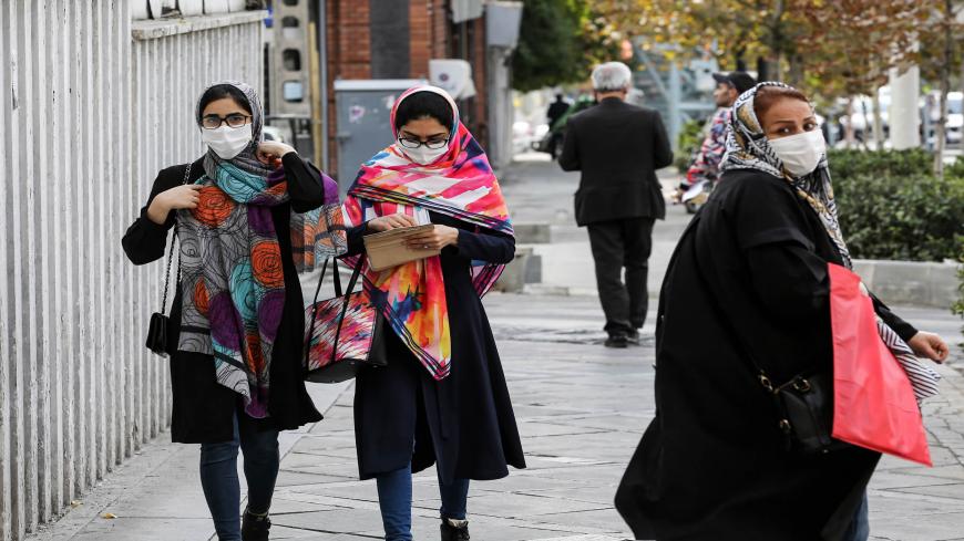 Women, mask-clad due to the COVID-19 coronavirus pandemic, walk along a street in Iran's capital Tehran on November 8, 2020. (Photo by ATTA KENARE / AFP) (Photo by ATTA KENARE/AFP via Getty Images)