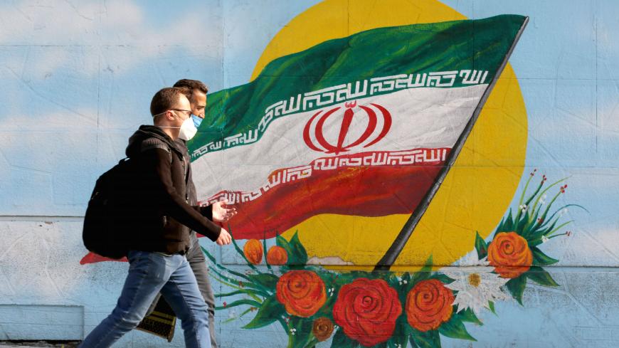 Men walk while wearing face masks amid the COVID-19 pandemic in the Iranian capital Tehran, on November 30, 2020. (Photo by ATTA KENARE / AFP) (Photo by ATTA KENARE/AFP via Getty Images)