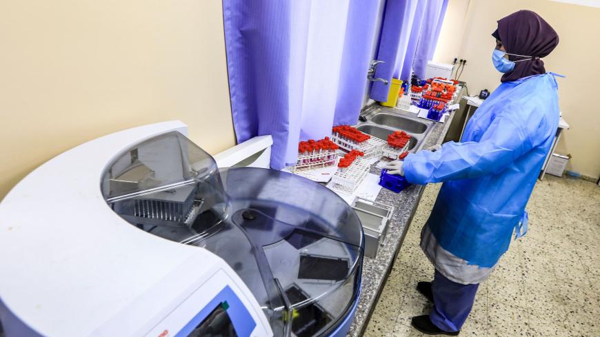 A technician handles collected PCR (polymerase chain reaction) swab samples collected as part of COVID-19 coronavirus disease testing, at the Palestinian Gaza-based Health Ministry central laboratory in Gaza City on December 7, 2020. - The Hamas-run Health Ministry in the Gaza Strip announced on December 7 that it will stop testing for the novel coronavirus as it "ran out of examination materials". (Photo by MAHMUD HAMS / AFP) (Photo by MAHMUD HAMS/AFP via Getty Images)
