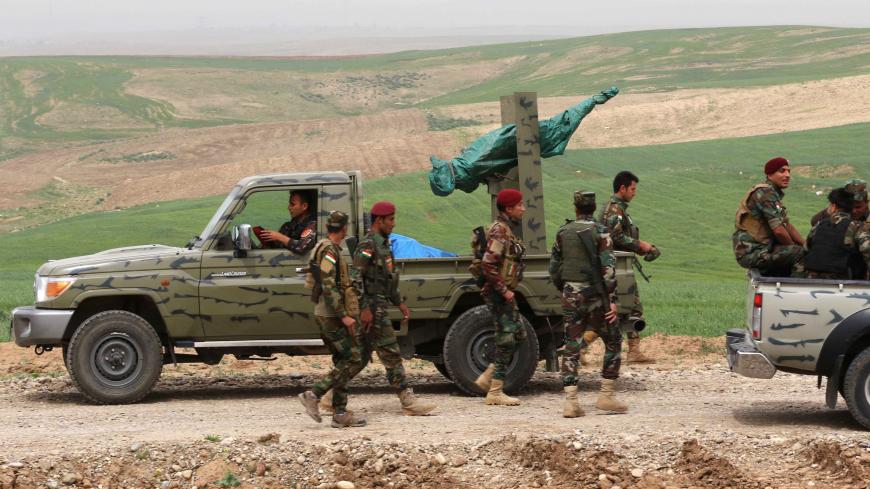 Syrian-Kurdish Peshmerga fighters and members of the Rojava Forces Defence Units walk near the town of Faysh Khabur, which lies in Iraq's Kurdish autonomous region near the three-way border crossing between Iraq-Syria-Turkey on March 29, 2018. / AFP PHOTO / SAFIN HAMED        (Photo credit should read SAFIN HAMED/AFP via Getty Images)