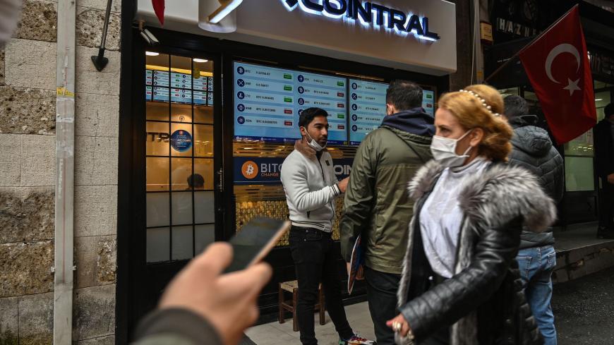 People pass in front of a crypto currency "Bitcoin Change" shop near the Grand Bazaar on December 17, 2020 in Istanbul. - Leading virtual currency bitcoin on 16 December traded above $20,000 for the first time following a sustained run higher in recent weeks. Bitcoin reached a record-high $20,398.50 before pulling back to $20,145, which was still an intra-day gain of nearly four percent. (Photo by Ozan KOSE / AFP) (Photo by OZAN KOSE/AFP via Getty Images)