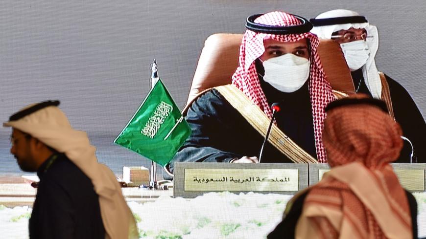 Journalists watch, Saudi Crown Prince Mohammed bin Salman addressing the attendees of the summit, on a screen in the media centre ahead of the 41st Gulf Cooperation Council (GCC) summit in the city of al-Ula in northwestern Saudi Arabia on January 5, 2021. - Saudi Arabia will reopen its borders and airspace to Qatar, US and Kuwaiti officials said, a major step towards ending a diplomatic rift that has seen Riyadh lead an alliance isolating Doha. The bombshell announcement came on the eve of GCC annual summi