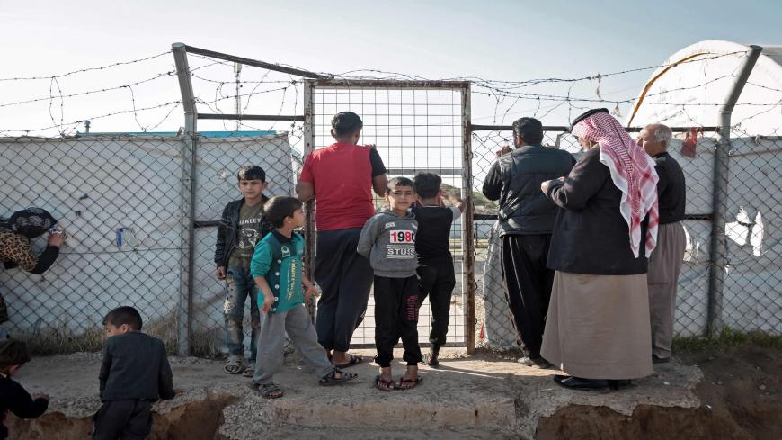 Families wait for food distribution at the Hasansham camp for internally displaced people in northern Iraq on December 10, 2020. - Rights groups and others -- including the International Organisation for Migration -- are worried about displaced families who stand accused of links to IS, sometimes falsely, and may face violent retribution if sent home. (Photo by FLORENT VERGNES / AFP) (Photo by FLORENT VERGNES/AFP via Getty Images)