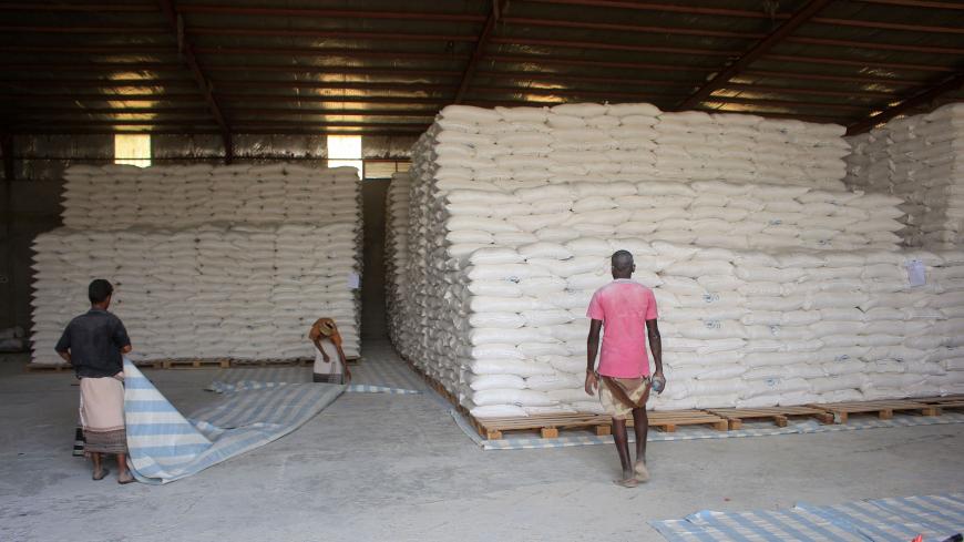 Workers transport food aid provided by the World Food Programme (WFP) before distributing rations to displaced Yemenis in the northern province of Hajjah, on January 12, 2021. (Photo by ESSA AHMED / AFP) (Photo by ESSA AHMED/AFP via Getty Images)