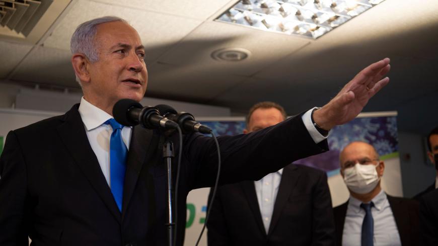 Israel's Prime Minister Benjamin Netanyahu visits the anti-coronavirus vaccination facility in the northern Israeli Arab city of Nazareth on January 13, 2021. - A group of Arab Israelis demonstrated against Netanyahu's visit to the fascililty in their city. Since July, thousands of Israelis have rallied each week to protest against the prime minister and the economic fallout from the pandemic. (Photo by Gil ELIYAHU / POOL / AFP) (Photo by GIL ELIYAHU/POOL/AFP via Getty Images)