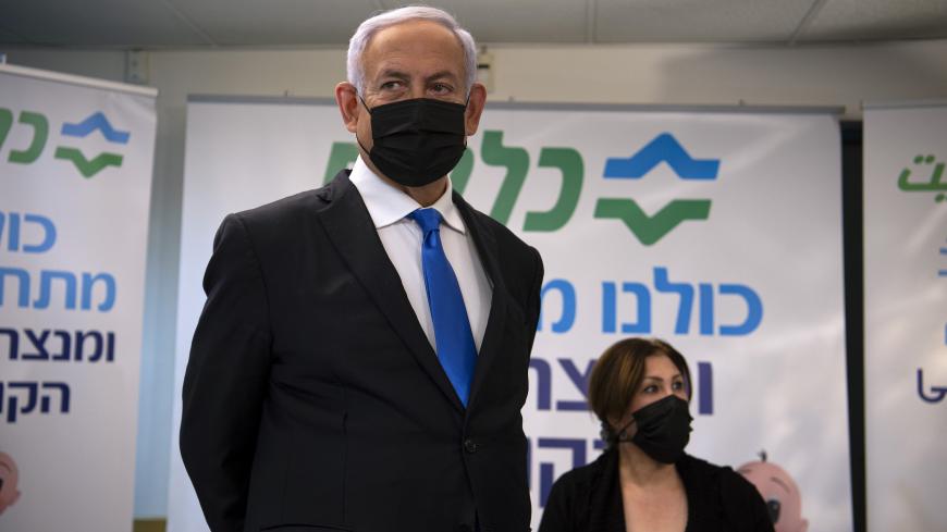 Israel's Prime Minister Benjamin Netanyahu visits the anti-coronavirus vaccination facility in the northern Israeli Arab city of Nazareth on January 13, 2021. - A group of Arab Israelis demonstrated against Netanyahu's visit to the fascililty in their city. Since July, thousands of Israelis have rallied each week to protest against the prime minister and the economic fallout from the pandemic. (Photo by Gil ELIYAHU / POOL / AFP) (Photo by GIL ELIYAHU/POOL/AFP via Getty Images)