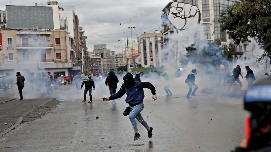 TOPSHOT - Lebanese anti-government protesters clash with security forces near the Serail (headquarters of the Governorate), in the northern port city of Tripoli, during a demonstration to protest against the economic situation, on January 28, 2021. - Tripoli was already one of Lebanon's poorest areas before the coronavirus pandemic piled new misery onto a chronic economic crisis. Many of its residents have been left without an income since Lebanon imposed a full lockdown earlier this month in a bid to stem 