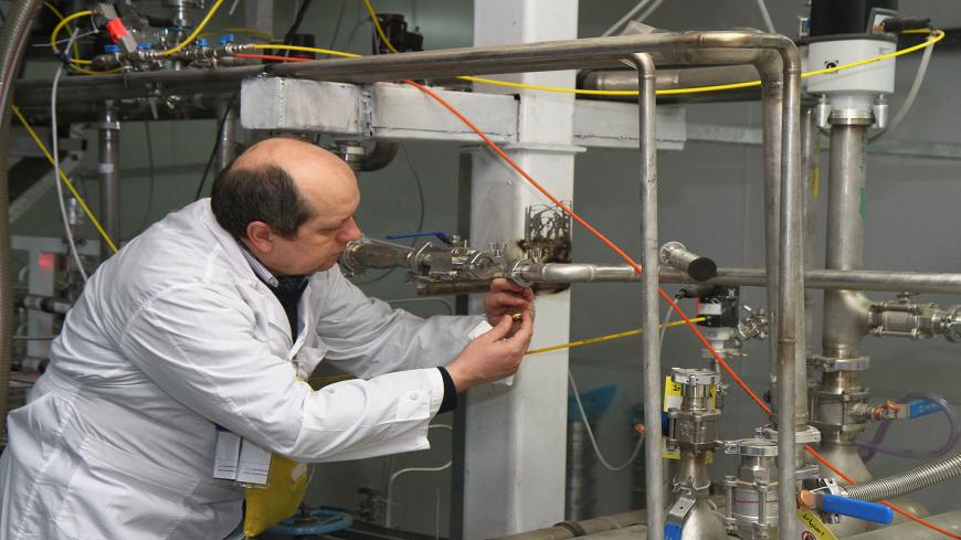 An unidentified International Atomic Energy Agency (IAEA) inspector disconnects the connections between the twin cascades for 20 percent uranium production at nuclear research centre of Natanz, some 300 kilometres south of Tehran on January, 20, 2014 as Iran halted production of 20 percent enriched uranium, marking the coming into force of an interim deal with world powers on its disputed nuclear programme. AFP PHOTO/IRNA/KAZEM GHANE (Photo by KAZEM GHANE / IRNA / AFP) (Photo by KAZEM GHANE/IRNA/AFP via Get